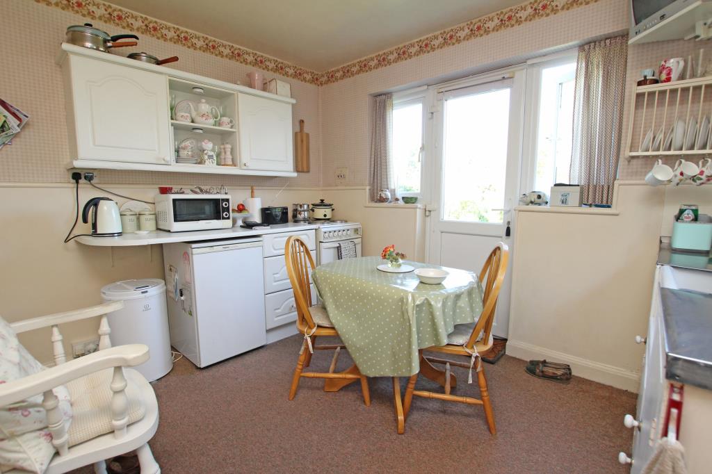 Lot: 129 - DETACHED BUNGALOW LET ON REGULATED TENANCY - Kitchen with door to rear garden taken August 2024